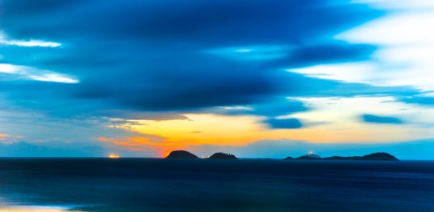 Imagem de pôr do sol na praia a partir da areia com lentes teleobjetivas criando perspectivas de cores e nuances em trabalho de característica própria do fotógrafo