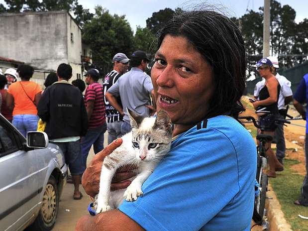 Fátima não esconde a alegria por ter reencontrado o gato que rondava a sua casa no Pinheirinho. Foto: Vagner Magalhães/Terra