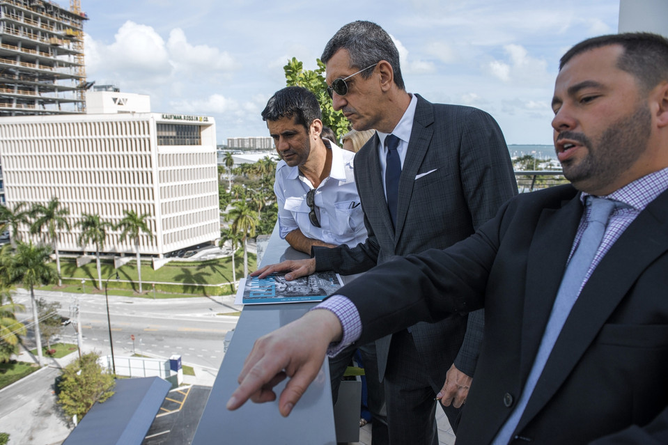 Displeased with his government, Brazilian Jose Antonio Parada, left, was recently shown a development in Miami, where he wants to move.